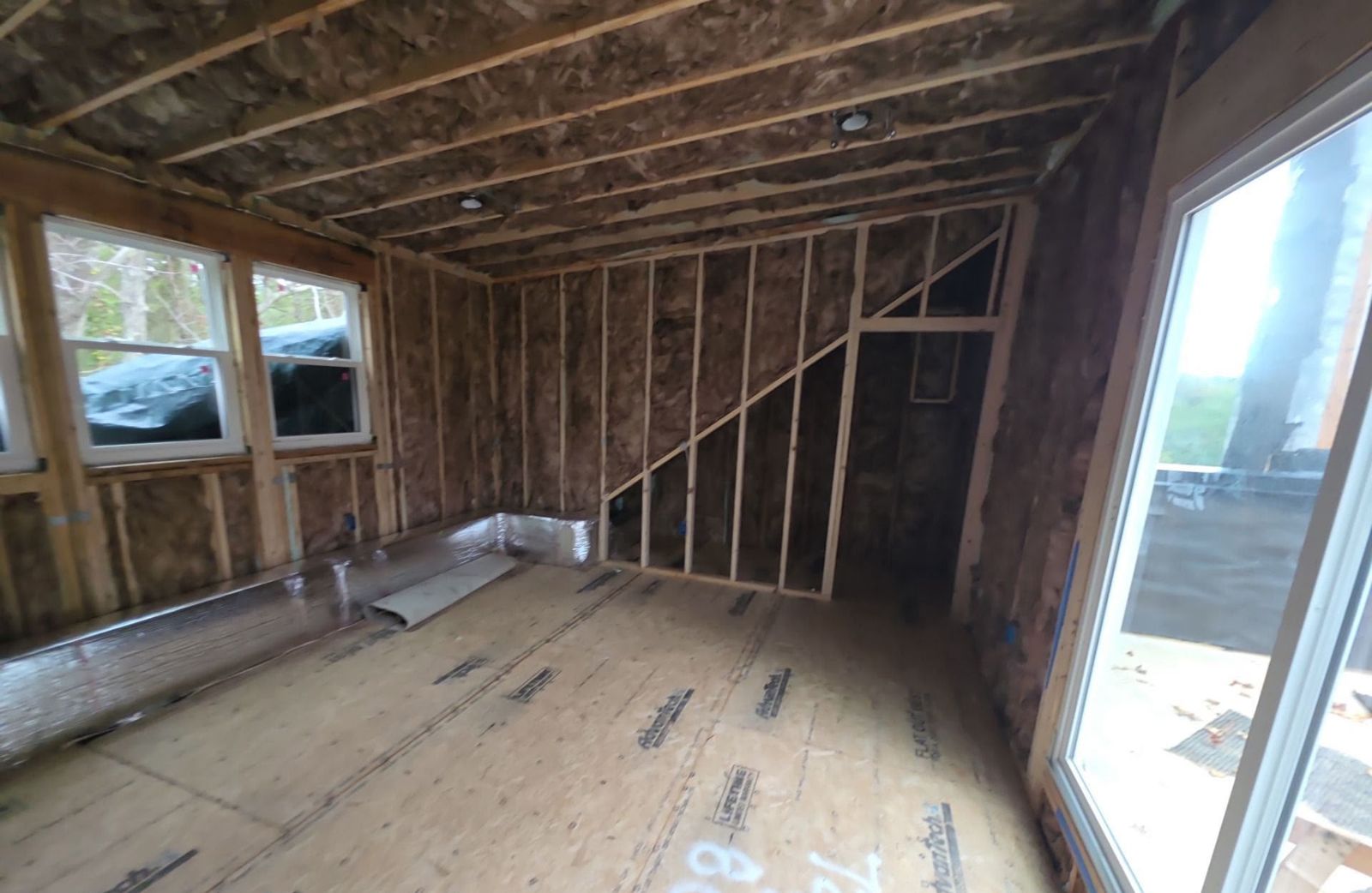 Room addition with sliding door and windows, ready for drywall